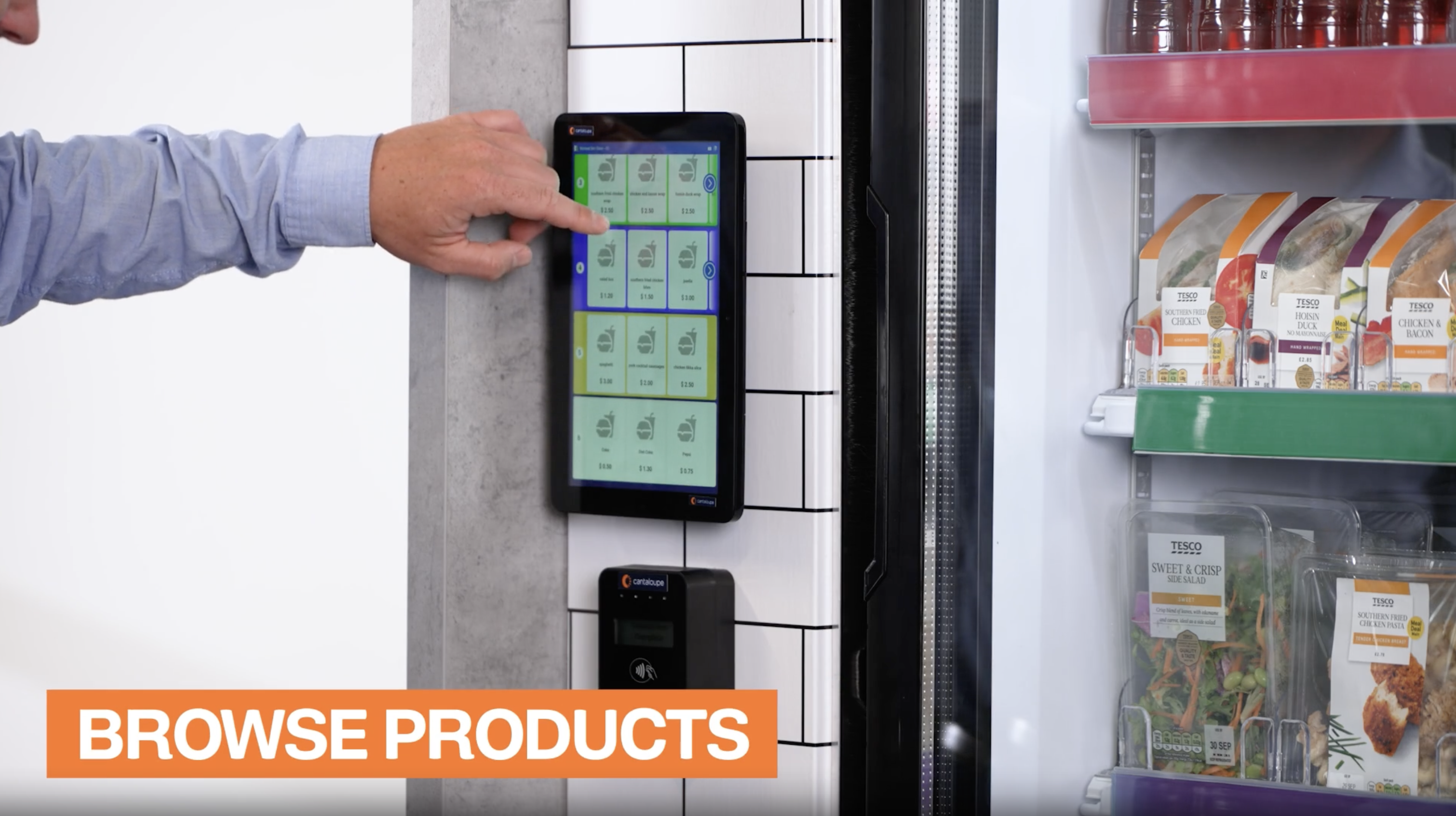 A man browsing products on the touchscreen of a cooler cafe.